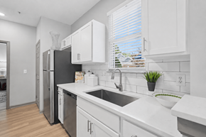 Winston Salem apartment for rent - A kitchen with white cabinets and a black fridge.