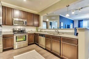 Mckinney apartment for rent - A kitchen with brown cabinets and stainless steel appliances.