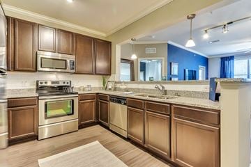 Mckinney apartment for rent - A kitchen with brown cabinets and stainless steel appliances.