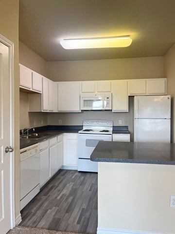San Antonio apartment for rent - A kitchen with white cabinets and a black countertop.