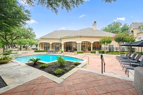 Dallas apartment for rent - a house with a swimming pool and a patio with chairs