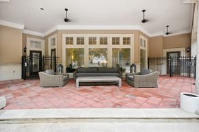 Dallas apartment for rent - a patio with couches and chairs in front of a building