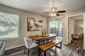 Houston apartment for rent - a dining room with a table and chairs and a ceiling fan