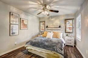 Houston apartment for rent - a bedroom with a bed and a ceiling fan