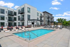 St. Louis Park apartment for rent - A swimming pool is surrounded by lounge chairs in front of apartment buildings.