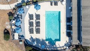 Wilmington apartment for rent - An aerial view of a swimming pool surrounded by lounge chairs and umbrellas.