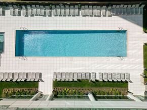 Chicago apartment for rent - A rectangular pool with a white tiled wall and a white bench with a black back.