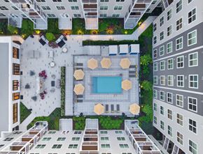 Waltham apartment for rent - A top-down view of a courtyard surrounded by buildings with a pool and seating areas.