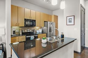 Tampa apartment for rent - A kitchen with a black counter top and wooden cabinets.