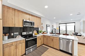 North Kansas City apartment for rent - A modern kitchen with wooden cabinets and stainless steel appliances.