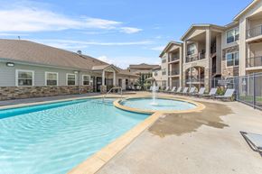 Kansas City apartment for rent - A swimming pool with a fountain in the middle of it.