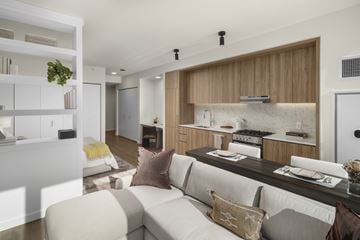 Chicago apartment for rent - A modern living room with a white couch and a kitchen area in the background.