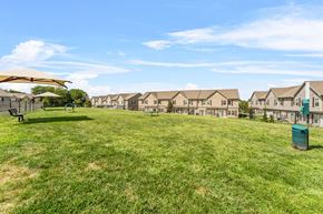 Kansas City apartment for rent - A grassy field with a row of houses in the background.