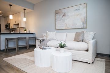 Pensacola apartment for rent - A living room with a white couch and a painting on the wall.