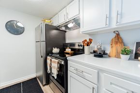 Independence apartment for rent - a kitchen with white cabinets and a stainless steel refrigerator