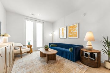 Kansas City apartment for rent - A living room with a blue couch and a wooden coffee table.