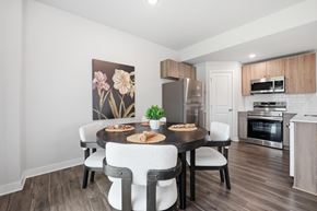 Kansas City apartment for rent - A dining room with a table set for two and a kitchen in the background.