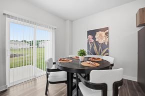 Kansas City apartment for rent - A dining room with a table set for two and a view of a parking lot outside.