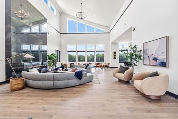 Lee's Summit apartment for rent - A modern living room with a large grey sofa and a wooden floor.