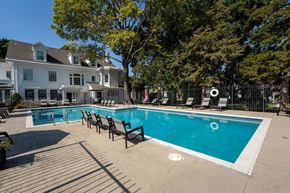 Independence apartment for rent - a swimming pool with chairs and a building in the background