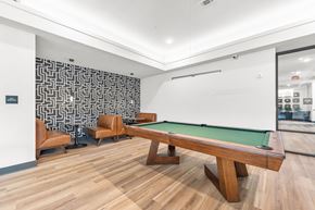 Lee's Summit apartment for rent - A pool table is in the middle of a room with wood flooring.