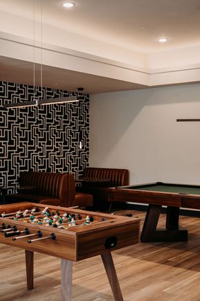 Lee's Summit apartment for rent - A foosball table is in the middle of a room with a pool table and a couch.