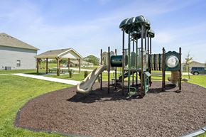 Blue Springs apartment for rent - Three Bedroom Townhomes In Blue Springs, MO - Chapman Ridge Townhomes - A Playground Includes Multiple Slides, Soft Mulch Ground, Picnic Tables, Sidewalk Paths, And Green Lawn.