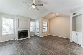 Orlando apartment for rent - A spacious living room with a fireplace and hardwood floors.