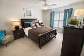 Greensboro apartment for rent - A bedroom with a large bed and a ceiling fan.