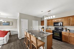 Kansas City apartment for rent - A kitchen with a black oven and wooden cabinets.