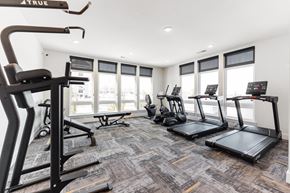 Raymore apartment for rent - A gym with treadmills, elliptical machines, and a weight machine.
