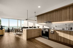 Chicago apartment for rent - A modern kitchen with wooden cabinets and a large window overlooking the ocean.