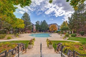 Littleton apartment for rent - a view of a swimming pool with trees and a building in the background