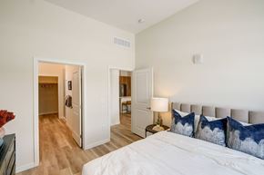 Aurora apartment for rent - A bedroom with a large bed and a mirrored closet door.