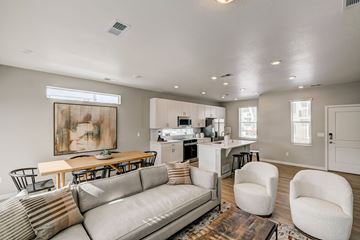 Aurora apartment for rent - A modern living room with a grey sofa and a wooden dining table.