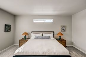 Aurora apartment for rent - A bedroom with a large bed and two lamps on the nightstands.