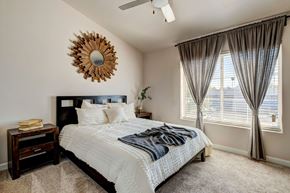 Phoenix apartment for rent - A bedroom with a large bed and a mirror on the wall.