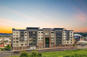 Tacoma apartment for rent - A modern apartment building with a green lawn in front.