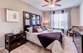 Fort Worth apartment for rent - A bedroom with a bed, nightstand, and a ceiling fan.