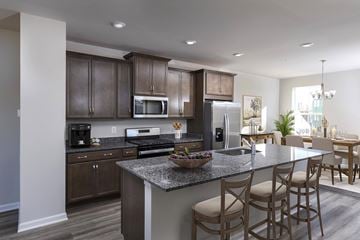 Waldorf apartment for rent - A modern kitchen with dark brown cabinets and a granite countertop.