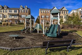 Waldorf apartment for rent - A playground with a green slide and a wooden swing set.