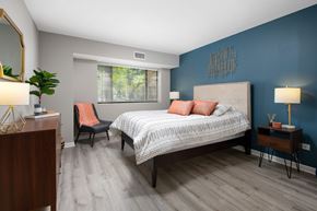 Arlington Heights apartment for rent - A bedroom with a bed, chair, and a plant.