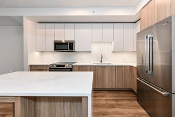 Washington apartment for rent - A modern kitchen with a white marble countertop and stainless steel appliances.