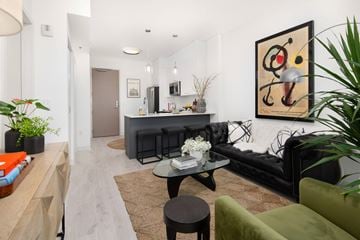Milwaukee apartment for rent - A living room with a black couch, a coffee table, and a painting on the wall.