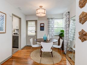 Asheville apartment for rent - A dining room with a table surrounded by chairs and a rug on the floor.