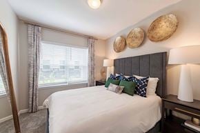 Roanoke apartment for rent - A bedroom with a large bed and a window with blinds.