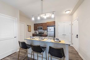 Roanoke apartment for rent - A kitchen with a table and chairs in front of a refrigerator and microwave.