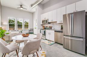 Pensacola apartment for rent - a kitchen with stainless steel appliances and a table and chairs
