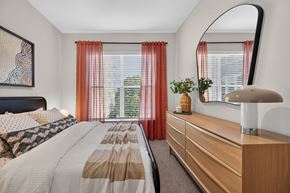 Waltham apartment for rent - A bedroom with a large bed and a mirror on the wall.