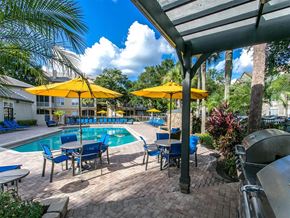 Orlando apartment for rent - a swimming pool with yellow umbrellas and blue and yellow chairs